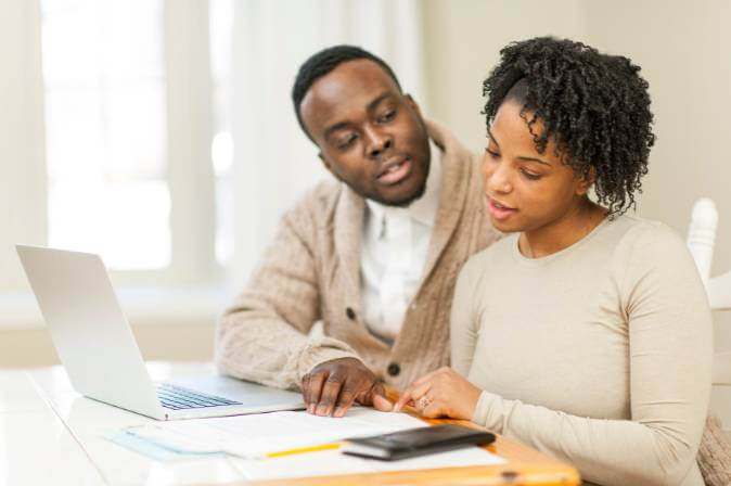 Black couple planning for retirement together and discussing a tax-deferred annuity.