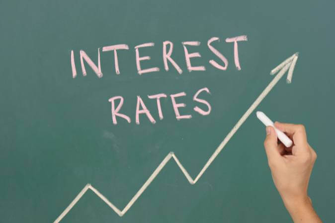 Photo of a chalkboard with a drawing of positive interest rate and the words "interest rate"