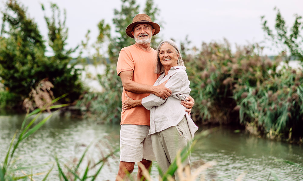 portrait of smiling senior couple with their arms around each other safe retirement income