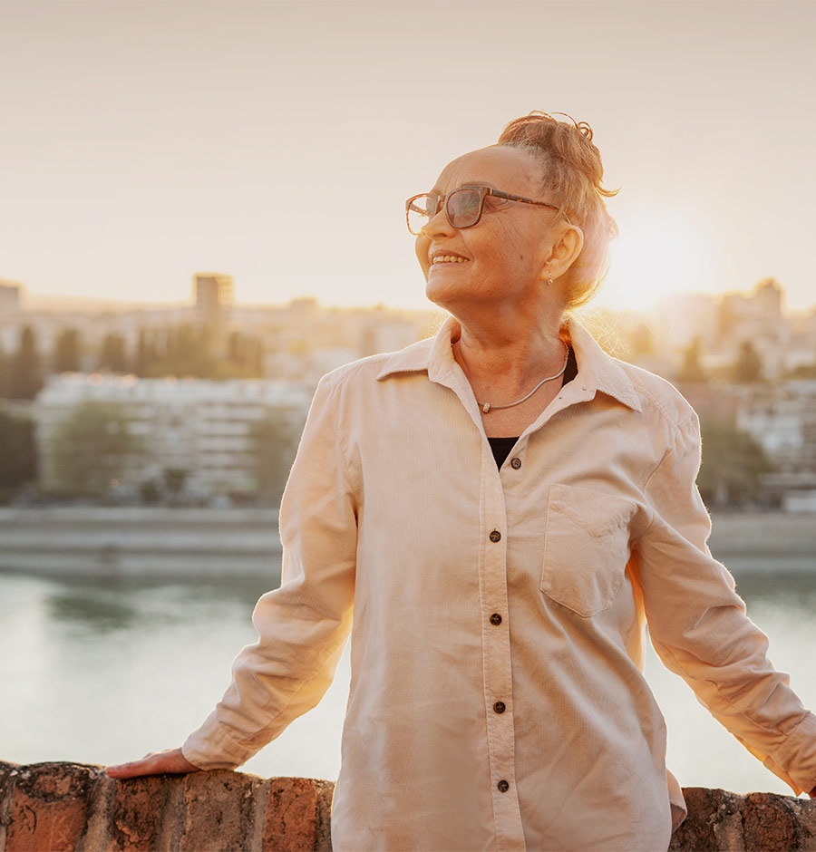 portrait of smiling senior woman with city in background how to save for a successful retirement